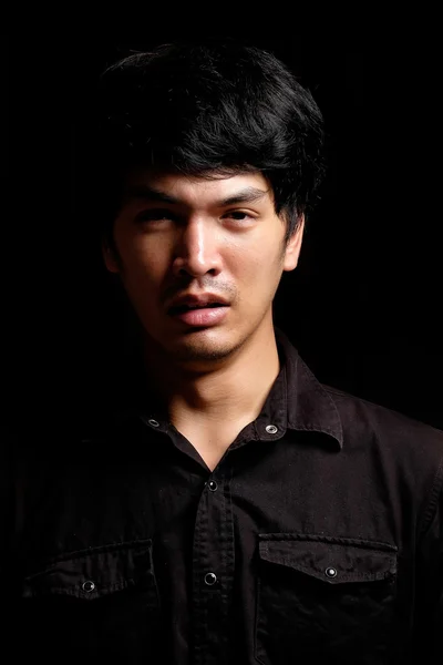 Asiatiska man porträtt i mörkret — Stockfoto