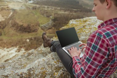 adam açık havada laptop ile çalışan