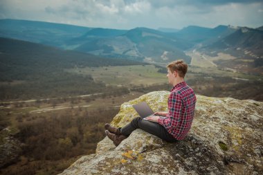 adam açık havada laptop ile çalışan