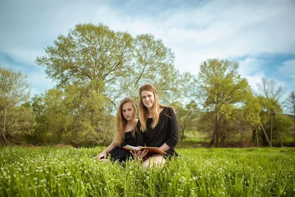 Girls reading the Bible on nature — Stock Photo, Image