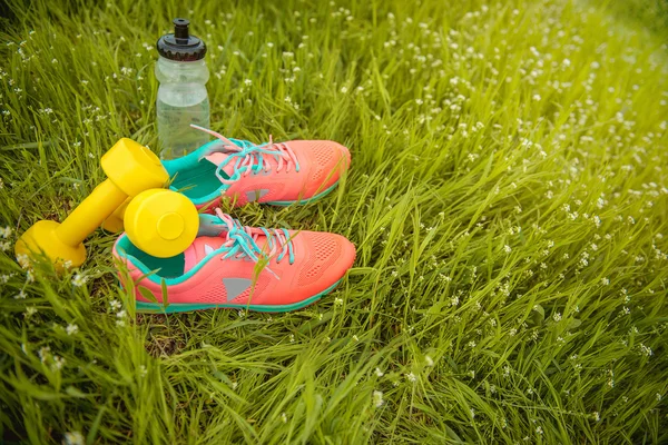 Sprzęt sportowy na tle zielonej trawy. Pojęcie zdrowego stylu życia — Zdjęcie stockowe