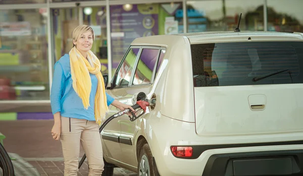 Meisje vult de auto met brandstof bij een tankstation — Stockfoto