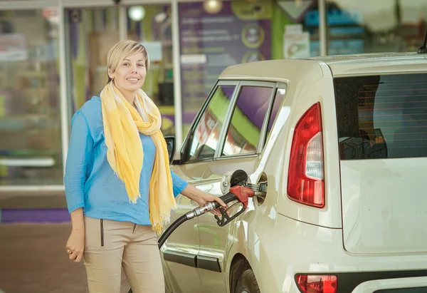 Meisje vult de auto met brandstof bij een tankstation — Stockfoto