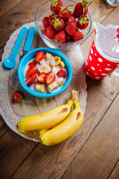 Batido de fresa y plátano en un vaso sobre una mesa de madera azul . —  Fotos de Stock