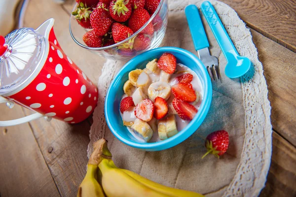 Batido de fresa y plátano en un vaso sobre una mesa de madera azul . —  Fotos de Stock