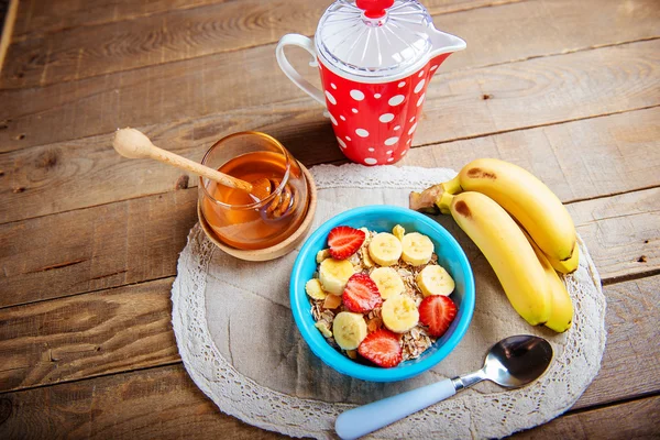 Müsli med färska jordgubbar och banan närbild på trä bakgrund. horisontella ovanifrån — Stockfoto