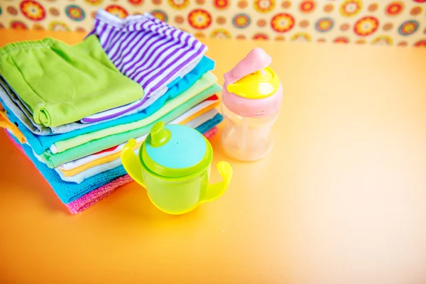 Nappflaska och babykläder — Stockfoto