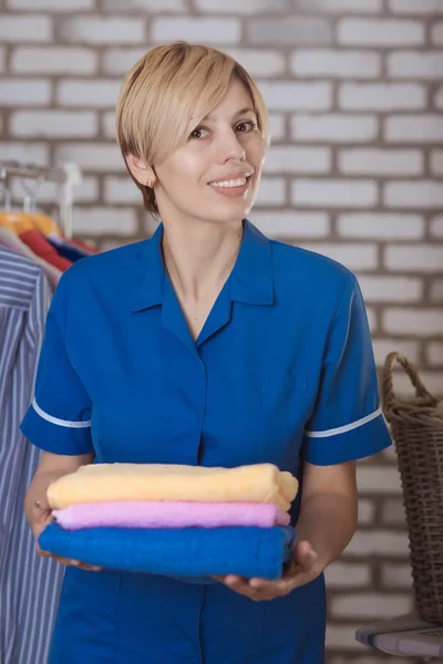 Maid with a stack of towels — Stock Photo, Image
