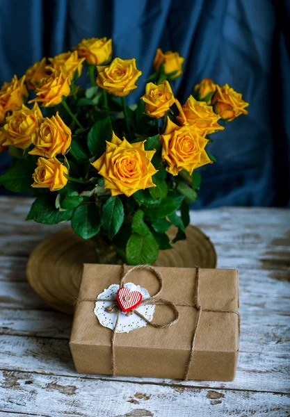 Gift box and a bouquet of yellow roses — Stock Photo, Image