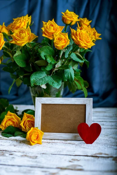 Bouquet of roses and picture frame — Stock Photo, Image