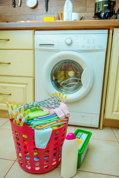 Tvättmaskin och en korg med barnkläder — Stockfoto