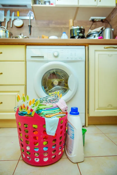 Waschmaschine und ein Korb mit Kinderkleidung — Stockfoto