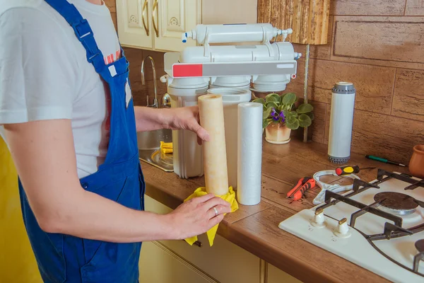 Tesisatçı mutfakta yeni su filtresi yükleme — Stok fotoğraf