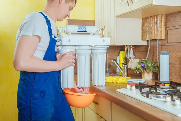 Plumber installing new water filter in the kitchen — Stock Photo, Image