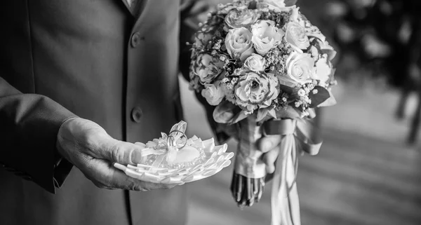 Wedding, groom with a bouquet of flowers and wedding rings — Stock Photo, Image