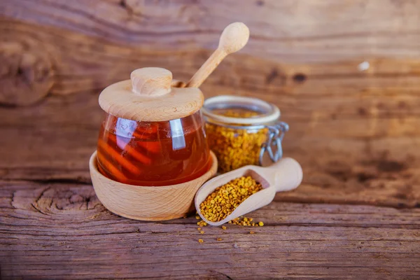 Honing en stuifmeel op een houten achtergrond — Stockfoto