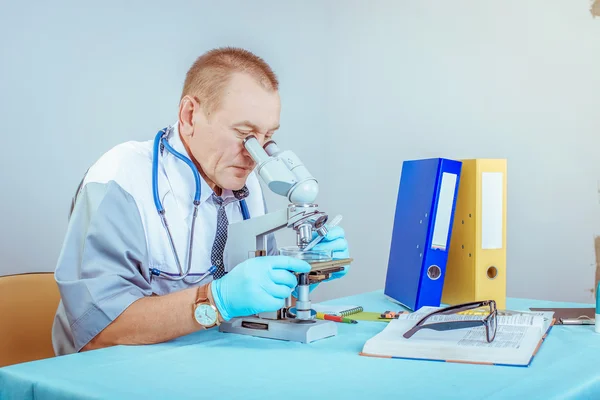 Πορτρέτο του ένα αρσενικό ο γιατρός με το μικροσκόπιο σε εργαστήριο — Φωτογραφία Αρχείου