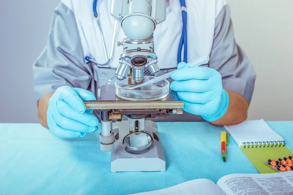 Retrato de um médico masculino com um microscópio em laboratório — Fotografia de Stock
