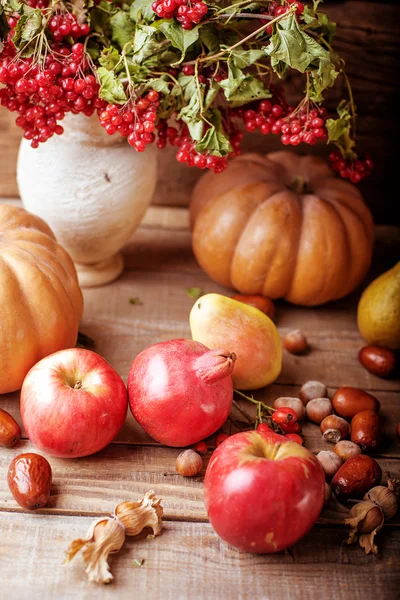 Herbststilleben. Kürbis und Früchte auf einem hölzernen Hintergrund — Stockfoto