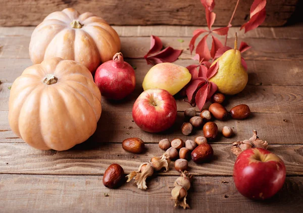Herbststilleben. Kürbis und Früchte auf einem hölzernen Hintergrund — Stockfoto