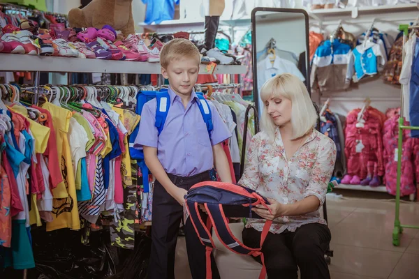 Ung vacker kvinna med barn i butik — Stockfoto