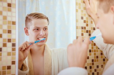 genç adam banyoda Dişlerini fırçalıyor화장실에서 그의 솔 질 하는 젊은이