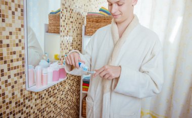 genç adam banyoda Dişlerini fırçalıyor화장실에서 그의 솔 질 하는 젊은이