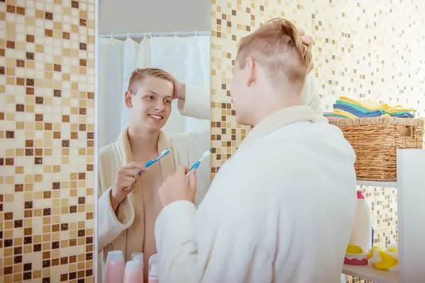 Молодой человек чистит зубы в ванной — стоковое фото
