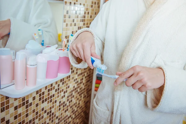 Foto de primer plano del hombre poniendo pasta de dientes en el cepillo de dientes en el baño — Foto de Stock
