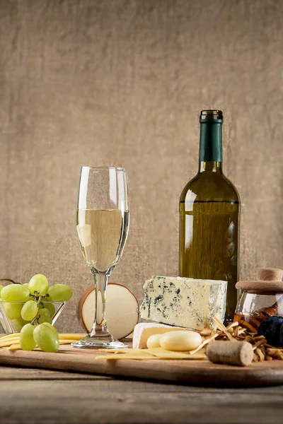 Various types of cheese, grapes, honey,  bottle of wine — Stock Photo, Image