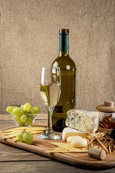 Various types of cheese, grapes, honey,  bottle of wine — Stock Photo, Image