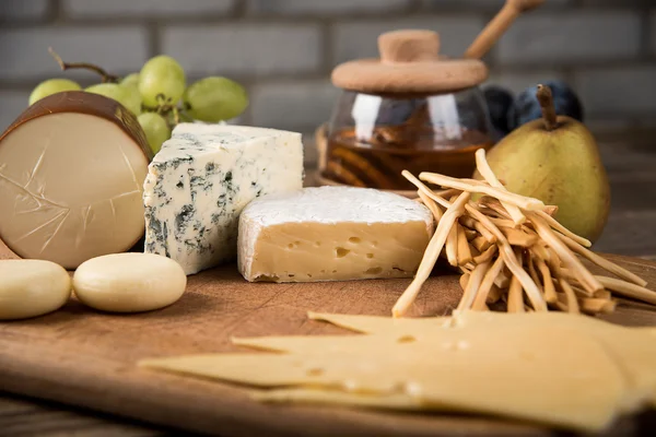 Assorted cheeses in various shapes and sizes — Stock Photo, Image