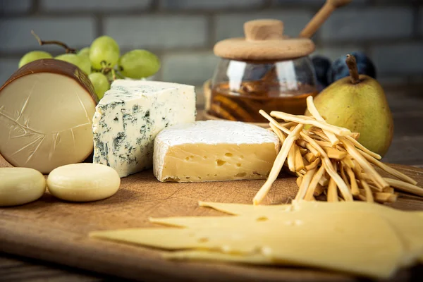 Assorted cheeses in various shapes and sizes — Stock Photo, Image