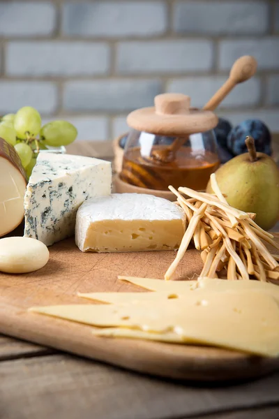 Assorted cheeses in various shapes and sizes — Stock Photo, Image