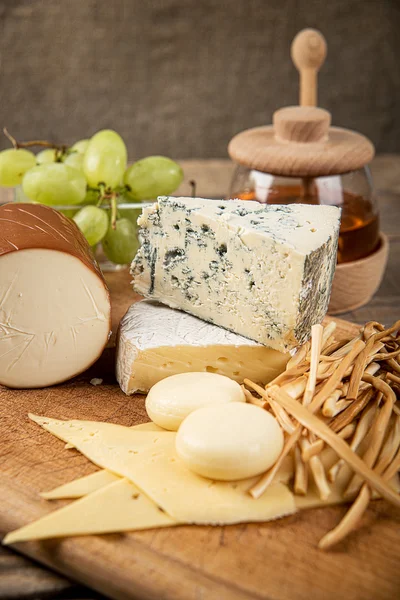 Assorted cheeses in various shapes and sizes — Stock Photo, Image