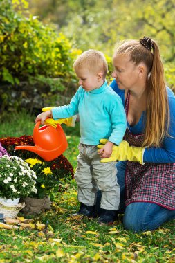 Young woman with a child are planting flowers 