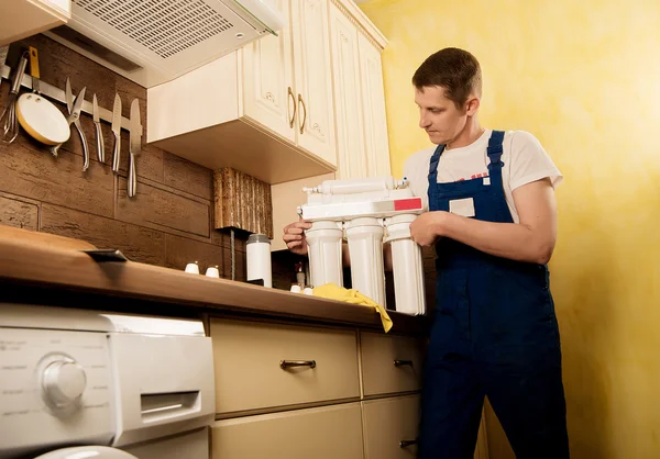 Locksmith installs water filter — Stock Photo, Image