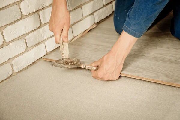 Man puts laminate — Stock Photo, Image