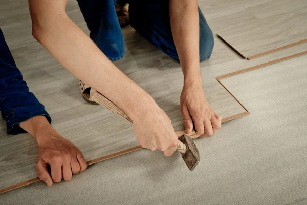 Man puts laminate — Stockfoto