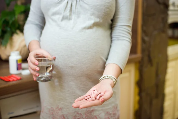 Young  pregnant woman taking pills, — Stock fotografie