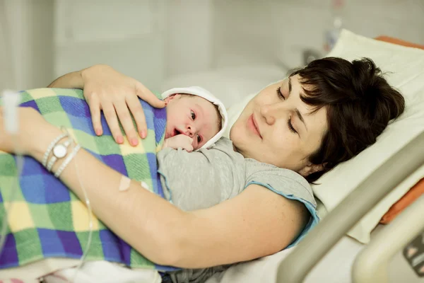 Happy woman after birth with a newborn baby — Stock Photo, Image