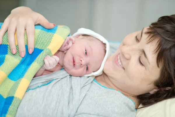 Happy woman after birth with a newborn baby — Stok fotoğraf