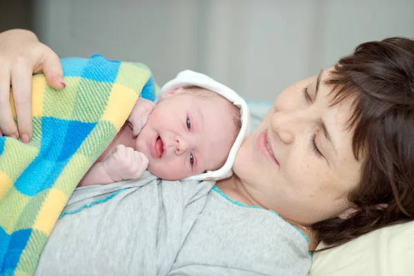 Happy woman after birth with a newborn baby — Stok fotoğraf