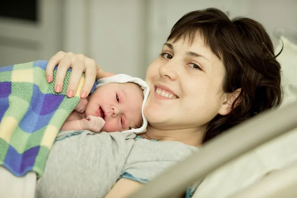Mulher feliz após o nascimento com um bebê recém-nascido — Fotografia de Stock