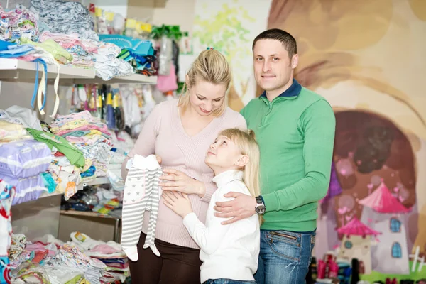 Pregnant woman buying baby clothes in supermarket — Stock Photo, Image