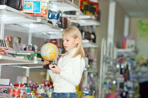 Flicka köper skolan tillbehör. — Stockfoto