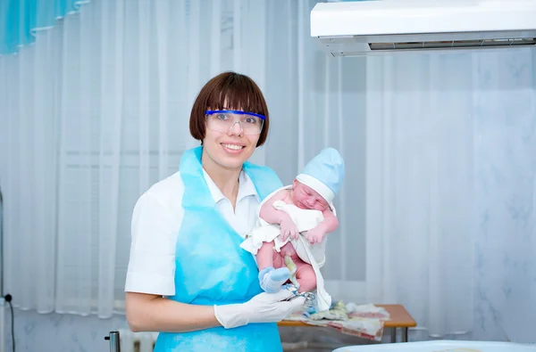 Happy doctor with a baby in her arms — Stock Photo, Image