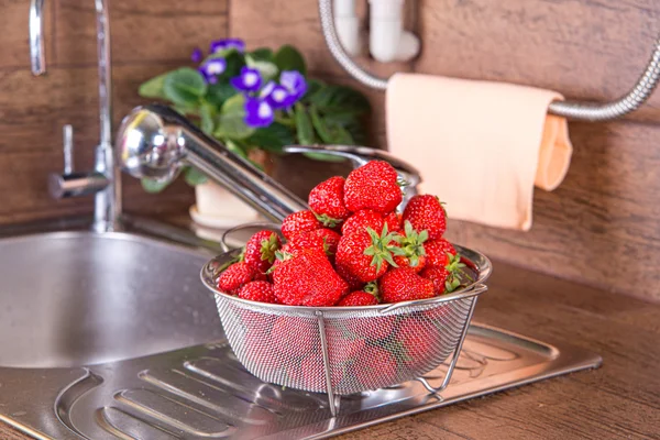 Girl washes strawberries — Stock Photo, Image