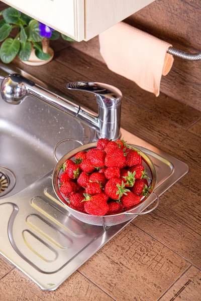 Girl washes strawberries — Stock Photo, Image