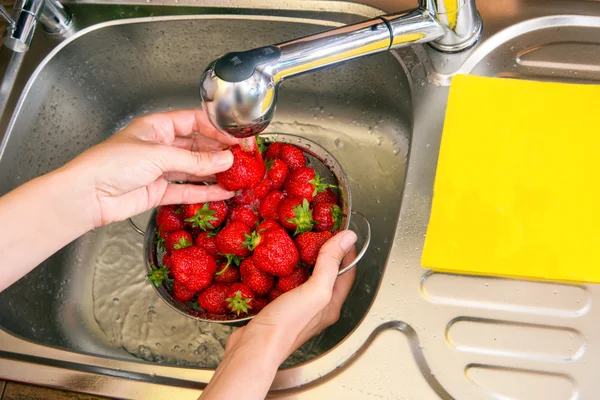 Girl washes strawberries — Stock Photo, Image